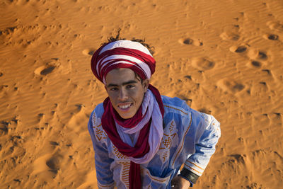 Portrait of smiling young man standing on sand