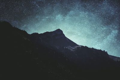 Scenic view of silhouette mountains against sky at night