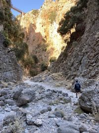 Rear view of man on rock by mountain