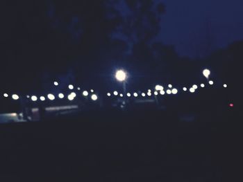 Defocused image of illuminated street lights in city at night