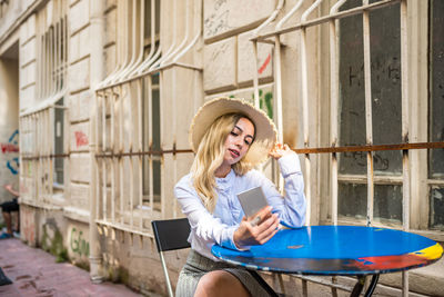 Full length of young woman using mobile phone