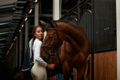 Side view of woman standing in stable