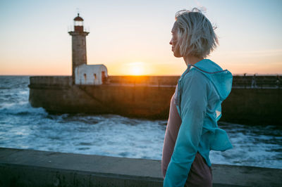 Portrait of young woman looking to sea at sunset