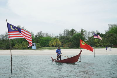 People on boat against sky