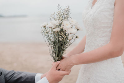 Midsection of woman holding flower bouquet