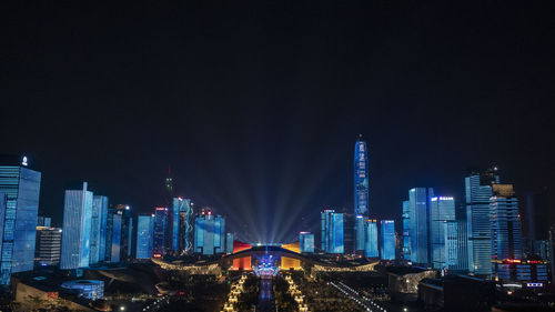 Illuminated buildings in city against sky at night
