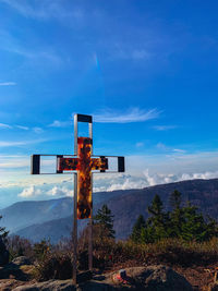 Cross on tree against blue sky