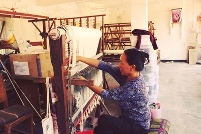 Woman weaving wool at home