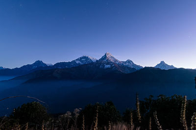 Scenic view of mountains against clear blue sky at night