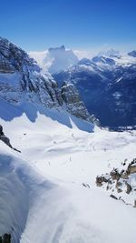 Scenic view of snow covered mountain against blue sky