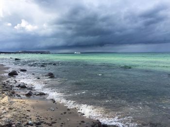 Scenic view of sea against storm clouds