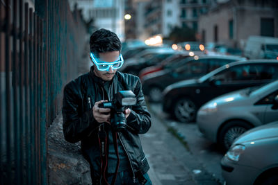 Full length of man using mobile phone while standing on street