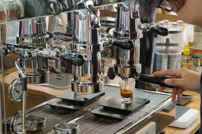 Cropped image of barista making coffee in cafe