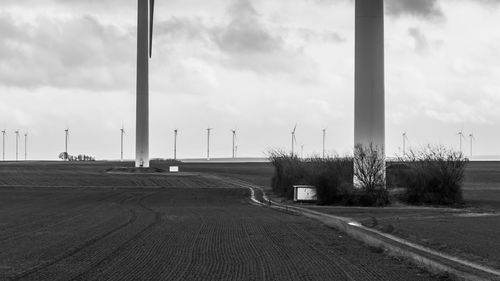 Empty road amidst field against sky