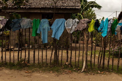 Clothes drying on clothesline by fence against building