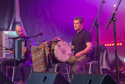 Full length of young man playing music concert