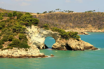 Rock formations by sea against sky