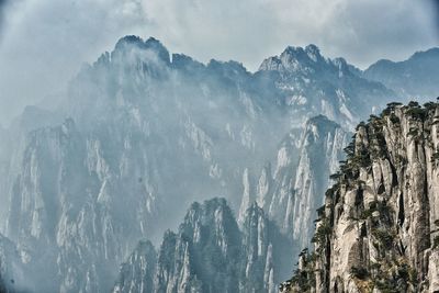 Scenic view of rocky mountains during foggy weather