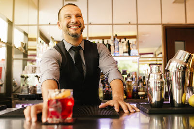 Smiling bartender at bar