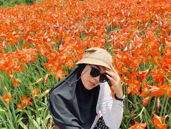 Portrait of young woman wearing sunglasses in flowering field