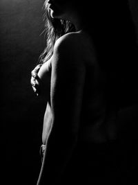 Naked woman standing in darkroom