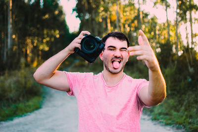 Portrait of smiling young man with camera