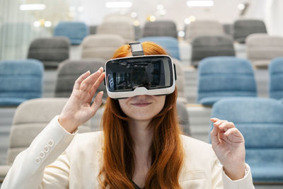 Working woman using virtual reality headset in convention center at office