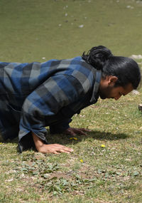 Close up side view of a handsome long haired indian young man doing push ups in the mountain