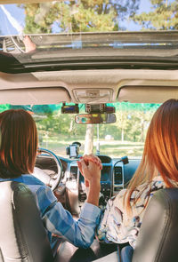 Rear view of friends traveling in car