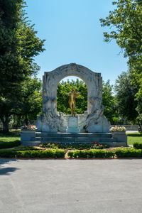 Statue by trees against sky