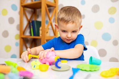 High angle view of cute baby boy playing with toys on table