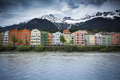 Buildings by mountains against sky during winter