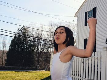 Young woman standing against building