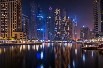 Reflection of illuminated buildings in city at night