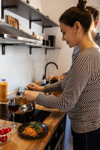 Side view of young woman preparing food