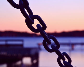Close-up of chain against sky during sunset