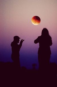 Silhouette people standing against sky during sunset