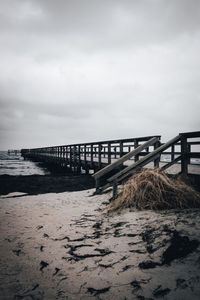 Pier over sea against sky. moody skies. 