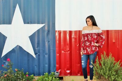 Woman standing against corrugated wall