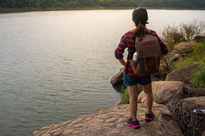 Full length of young woman standing on riverbank
