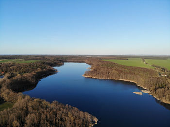 Scenic view of lake against clear blue sky