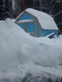 Snow covered house by building