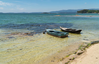 Boats moored in sea against sky