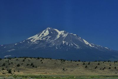 Scenic view of snowcapped mountains against clear blue sky