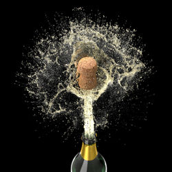 Close-up of champagne splashing against black background
