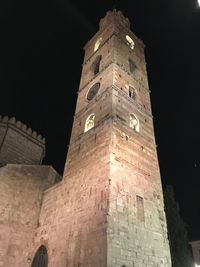 Low angle view of clock tower against sky at night