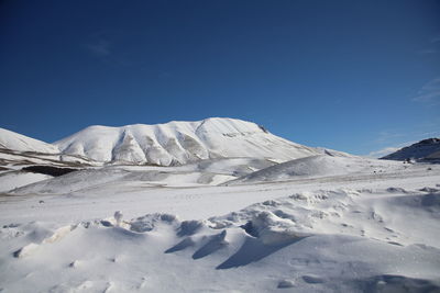 Close-up of snowcapped mountains against clear blue sky