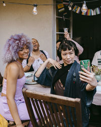 Transwoman taking selfie with friends of lgbtq community during dinner party in back yard