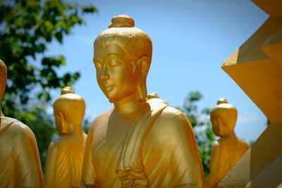 Low angle view of statue against temple building against sky