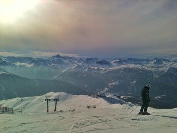 People on snowcapped mountain against sky